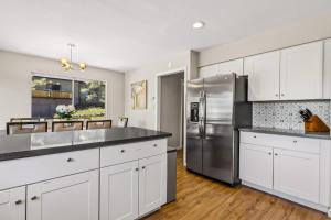 a kitchen with white cabinets and a stainless steel refrigerator at High Country Rretreat in Flagstaff +23 photos