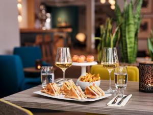 a table with two plates of food and glasses of wine at Hotel Ambassador Zermatt in Zermatt +34 photos