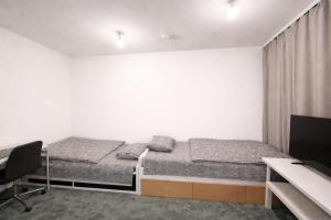 a bedroom with two beds and a desk and a computer at City Heaven in Turku