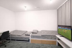 a room with two beds and a flat screen tv at City Heaven in Turku