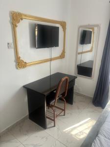 a black desk with a chair and a mirror at Otijoe Premier Hotel in Port Harcourt
