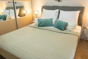 a large white bed with blue pillows and a mirror at Cozy Spot in Ixia