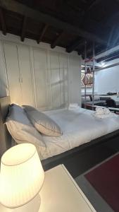 a bed with pillows and a lamp in a room at Casa in Piazzetta in Zagarolo