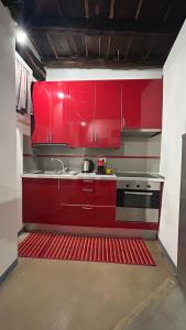 a kitchen with red cabinets and a sink at Casa in Piazzetta in Zagarolo +3 photos