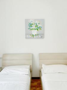 two beds in a room with a painting on the wall at Affittacamere Seveso in Milan