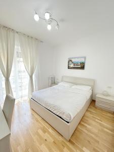 a white bedroom with a bed and a window at Affittacamere Seveso in Milan