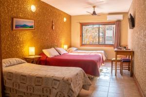 a hotel room with two beds and a window at Hotel Xumec Mendoza Centro in Mendoza