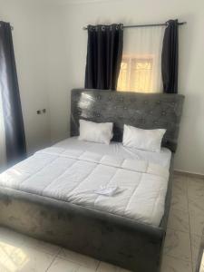 a bed with white sheets and pillows in a room at Otijoe Premier Hotel in Port Harcourt