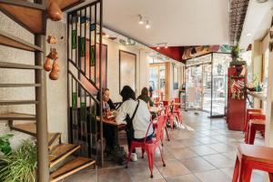 a group of people sitting at tables in a restaurant at Hotel Xumec Mendoza Centro in Mendoza