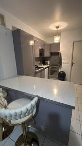 a kitchen with a counter and a bar with a stool at Maison a côté de Disney in Chessy +1 photo