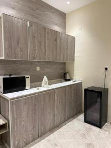 a kitchen with wooden cabinets and a microwave on a counter at Marina Jada hotel in Jeddah +21 photos