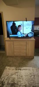 a flat screen tv sitting on top of a wooden stand at Masčio apartamentai in Telšiai
