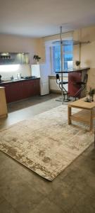 a large living room with a table and a rug at Masčio apartamentai in Telšiai