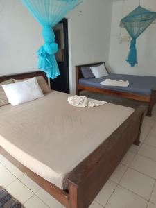 a bedroom with two beds with blue drapes at Polhena Coral Reef Resort in Matara