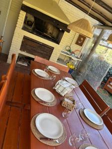 a wooden table with plates on top of it at Casa en Complejo Sierra Alta in Punta del Este