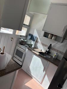 a small kitchen with a sink and a stove at Casa en Complejo Sierra Alta in Punta del Este +1 photo