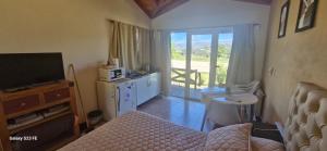 a bedroom with a bed and a television and a balcony at Loma Alta Apart in Villa Yacanto