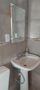 a bathroom with a sink and a mirror and a toilet at Loma Alta Apart in Villa Yacanto +33 photos