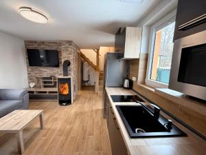a kitchen with a stove and a living room at Chalet U Pstruha in Vimperk +5 photos