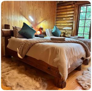 a bedroom with a large bed in a log cabin at Little Lions in Dullstroom