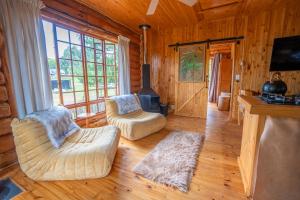 a living room with two chairs and a fireplace at Little Lions in Dullstroom
