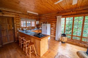 a kitchen with an island in a log cabin at Little Lions in Dullstroom