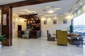 a lobby with a bar with couches and chairs at Alqasr Almutar Hotel in Abha