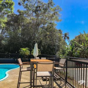 a patio with a table and chairs next to a swimming pool at Morada do Estaleiro in Balneário Camboriú +47 photos