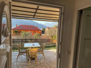 a patio with a table and chairs and a view of a house at Apartmani BOBO in Kotor