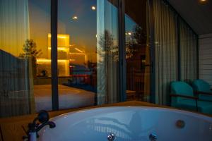 a bath tub in a room with a bedroom at Hamta 270 Cliff Resort - 270 Degree Mountain View Suites, Sethan Manali in Manāli