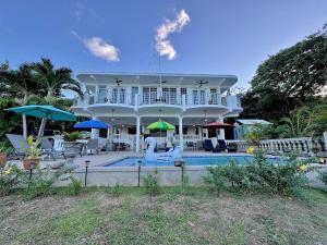 a large white house with a pool in front of it at Vieques BioBay Bed and Breakfast in Vieques