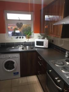 a kitchen with a sink and a microwave at Lakeside View, Perton Village in Wolverhampton