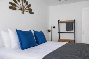 a bedroom with a bed with blue pillows at City center apartment with free parking and sauna in Tallinn