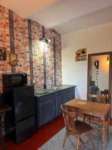 a kitchen with a stove and a table in a room at L Authentique Prairie in Alès +7 photos