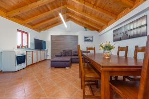 a kitchen and dining room with a table and a couch at Holiday home Atrium in Nin