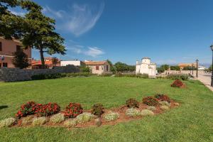 a garden with red flowers in a yard at Holiday home Atrium in Nin