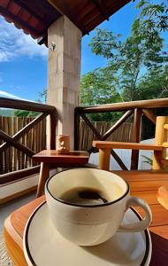 a cup of coffee sitting on a table on a balcony at Casa Brisa do Vale - Ar condicionado nos 2/4 .. in Lençóis