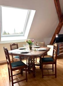 a dining room table with chairs and a large window at Gîte le Nid in Uffholtz +23 photos