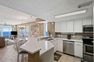 a kitchen with white cabinets and a dining room with the ocean at Jade East Towers 1850 in Destin +45 photos