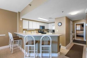 a kitchen with a large island with bar stools at Jade East Towers 0740 in Destin