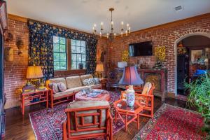 a living room filled with furniture and a brick wall at Terrace Carriage House in Natchez