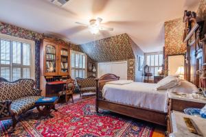 a bedroom with a bed and a table and chairs at Terrace Carriage House in Natchez
