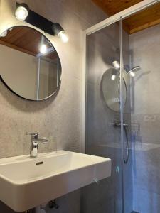 a bathroom with a sink and a shower with a mirror at Pension Patz in Schladming