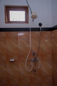a shower in a bathroom with a wooden floor at Cloud Nest Cabana in Ohiya