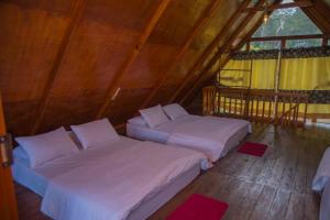 a room with two beds and a window at Cloud Nest Cabana in Ohiya