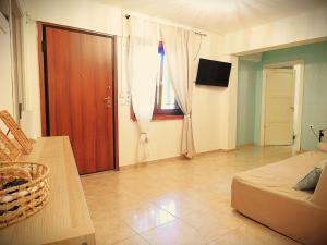 a living room with a bed and a wooden door at Eva's Eden in Vourvourou