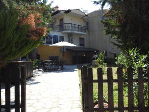 a fence in front of a house with an umbrella at Eva's Eden in Vourvourou