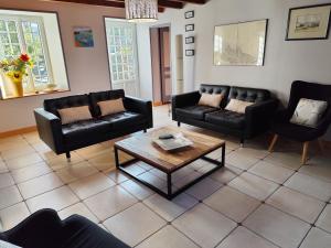 a living room with black couches and a coffee table at gite des vieilles rues in Omonville-la-Rogue +14 photos