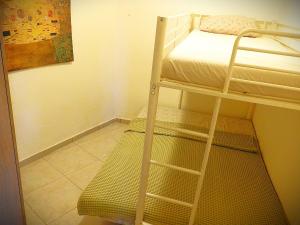 a bunk bed with a ladder next to a room with a bed at Eva's Eden in Vourvourou