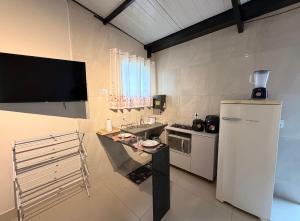 a small kitchen with a sink and a refrigerator at Flat 02 - Ar condicionado ao lado do Camaru, próximo ao UMC e shopping in Uberlândia